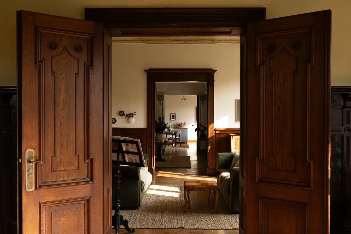 The villa's oak doors opening into sunlit rooms — workspace for corporate events